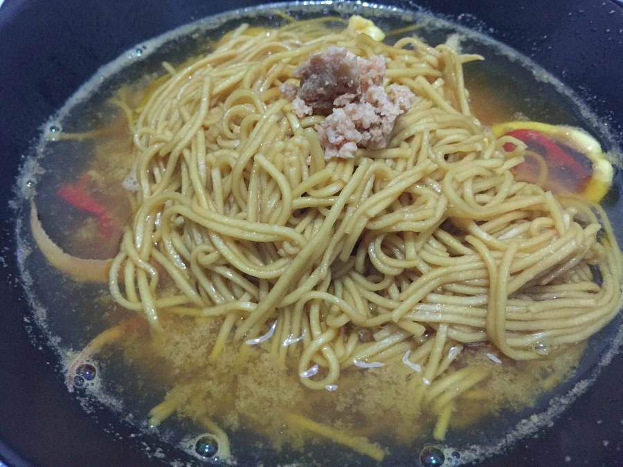 Noodles saltati con salsa di soia, brodo caldo di gamberone con anelli e tentacoli di calamaro, zafferano e peperoncino, bottarga di pesce spada